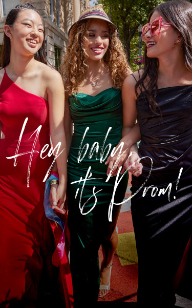 three girls in prom dresses walking down the street and smiling